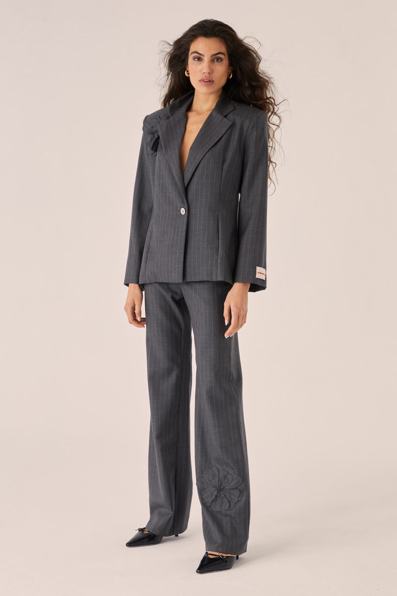 Señorita Adriana gray pants with a relaxed fit and subtle pleats, shown on a model in a casual setting.