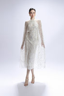White sequin midi cape dress by Valenciani, elegant gown with shimmering sequins and flowing cape detail.