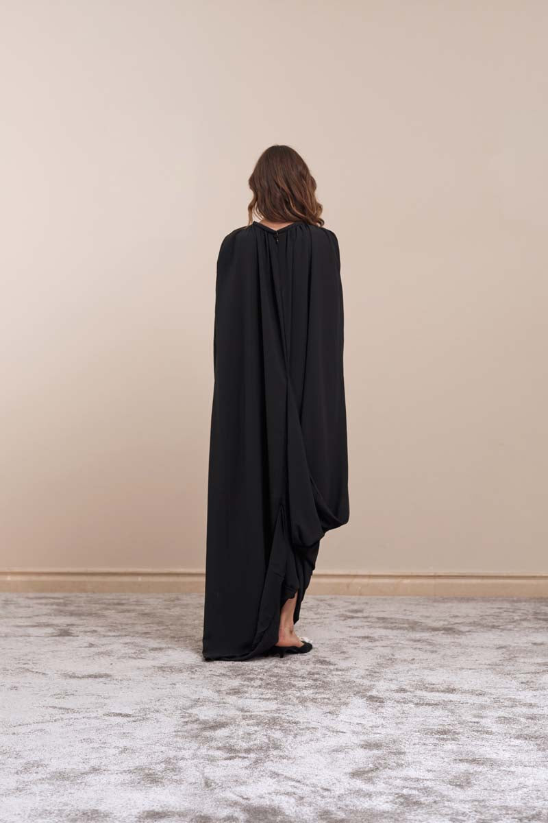 Black sheer midi dress by Yassmin Saleh with a flowing, elegant design and see-through fabric at the back.