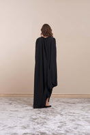 Black sheer maxi dress by YASSMIN SALEH featuring flowing fabric and elegant design, shown from the back view.