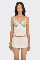 Off-white shell hand-embroidered bustier top by Stolen Stores, featuring intricate embroidery and a fitted design.