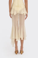 Light yellow sheer asymmetric maxi skirt from Stolen Stores featuring a shell-like design and flowing, elegant fabric.