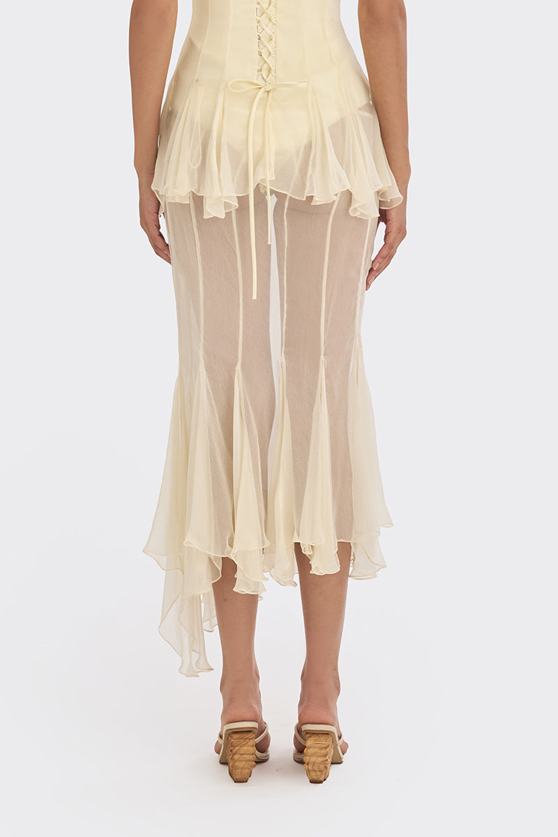Light yellow sheer asymmetric maxi skirt from Stolen Stores featuring a shell-like design and flowing, elegant fabric.