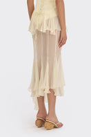 Light yellow asymmetric sheer maxi skirt from Stolen Stores featuring shell-shaped details and flowing, lightweight fabric.