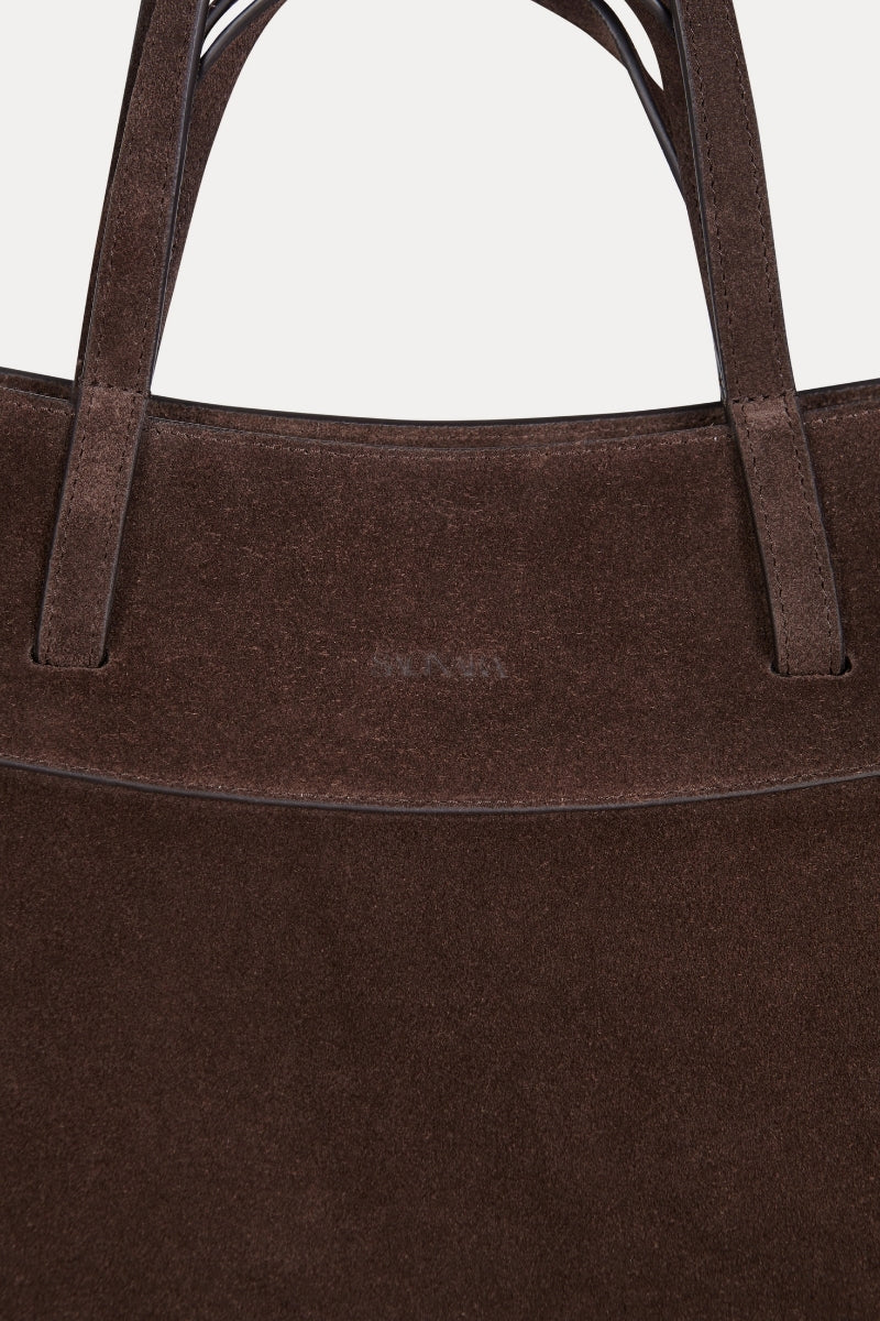 Saonara chocolate suede shoulder bag with sleek design and adjustable strap, showcasing its soft textured material and elegant shape.