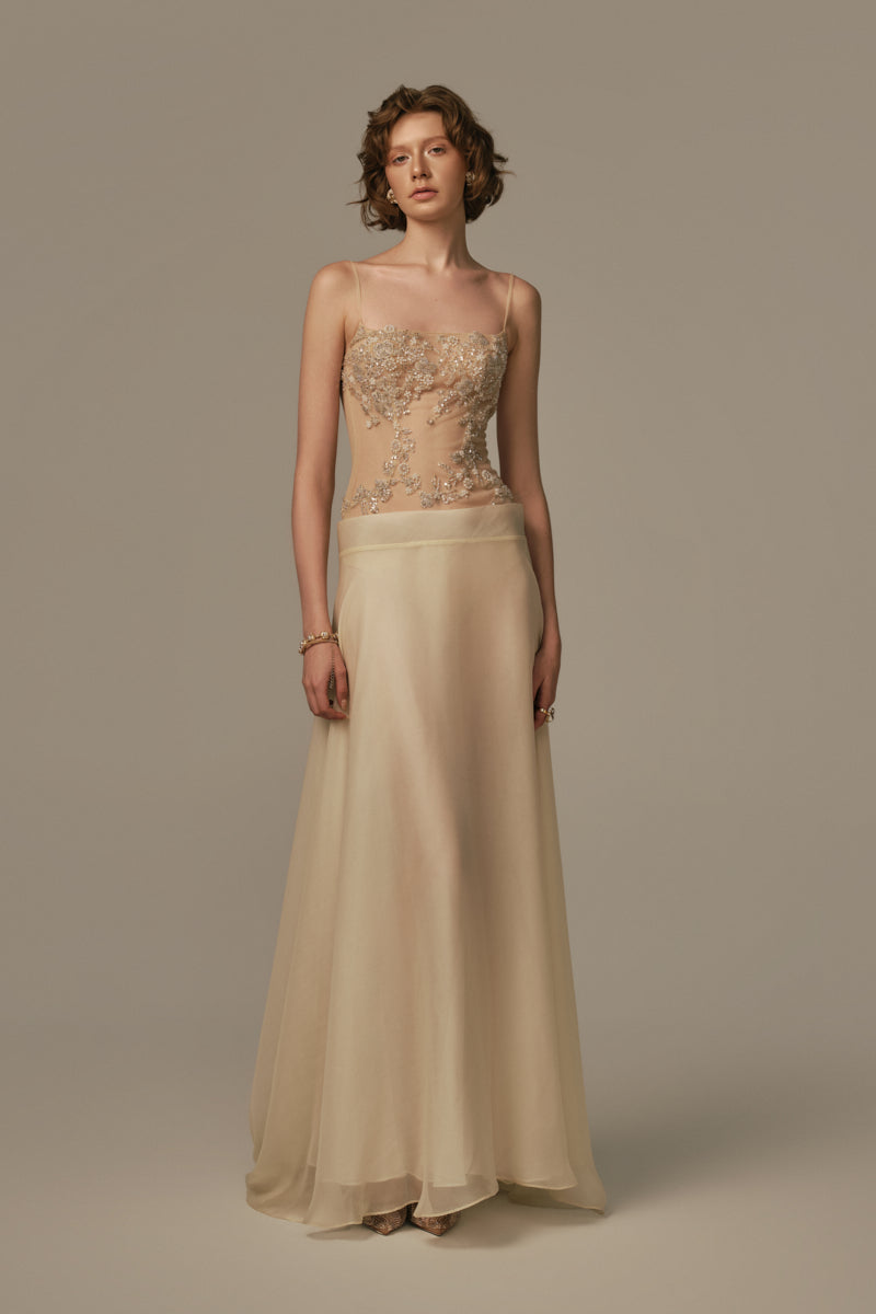 Pastel yellow POEM SEISTE MAXI DRESS with flowing fabric and elegant design, worn by a model in a bright, stylish setting.