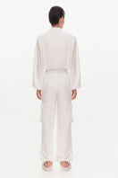 White Kris Marán silky bomber jacket shown from the back, featuring smooth fabric and stylish collar details.