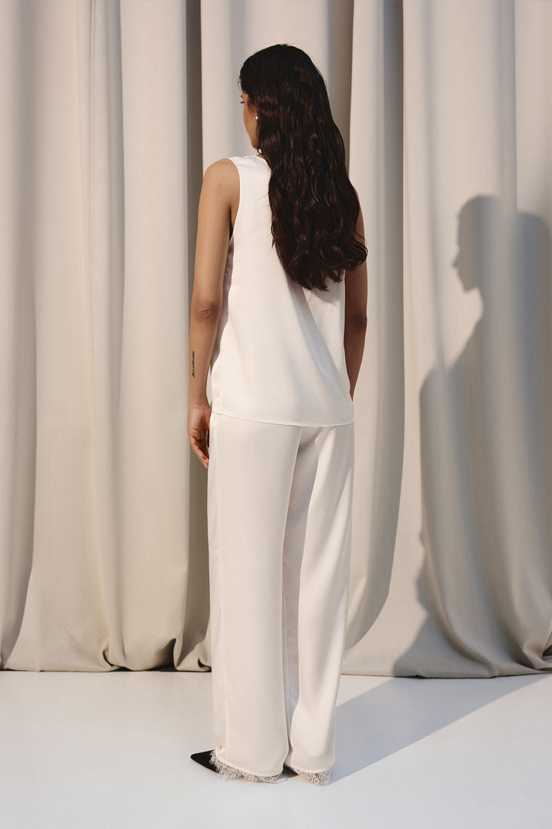 Ivory silk lounge pants with delicate lace trim by Kris Marán, featuring a relaxed fit and elegant design.