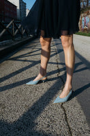 A pair of AERA Silvana blue denim slingback pumps with heels, showcasing stylish design and pointed toe on a neutral background.