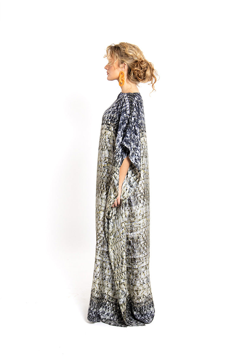 Model wearing Amel Batita Skin Brocot Kaftan maxi dress, flowing fabric with intricate brocot detailing, in a relaxed, elegant style.