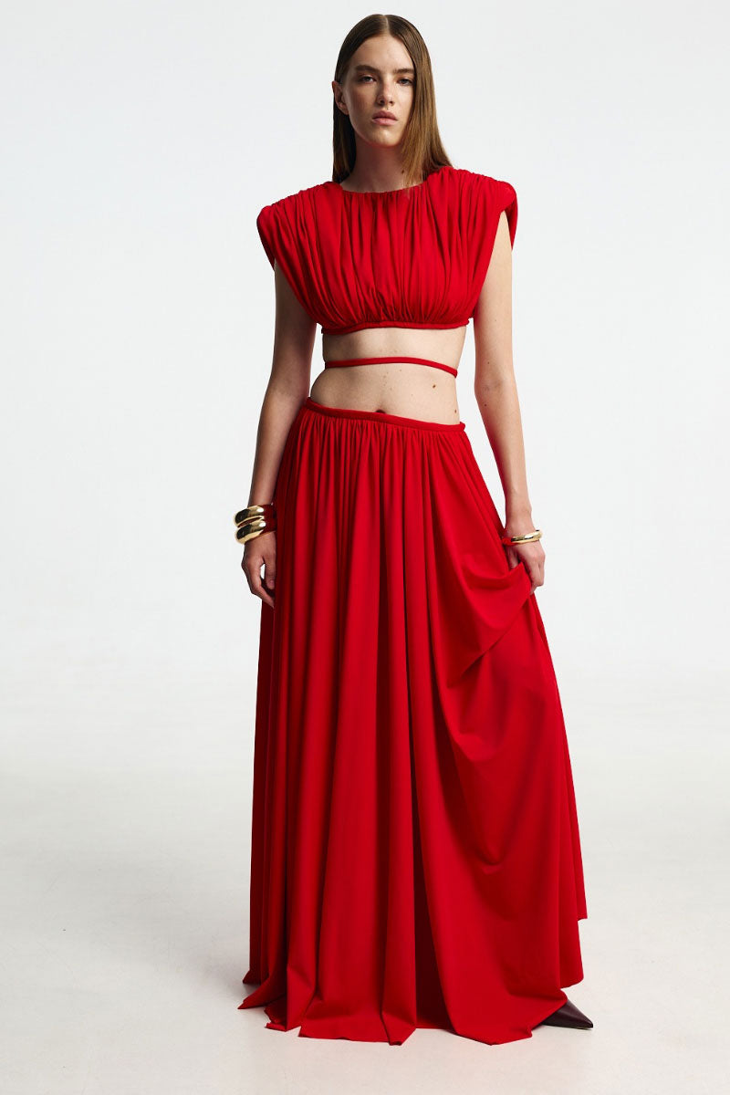 Red pleated maxi skirt from Santa Brands with flowing fabric and elegant design, perfect for stylish outfits.