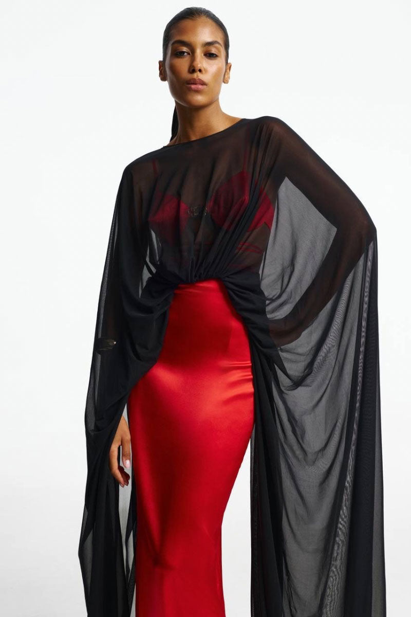 Red pleated maxi skirt by Santa Brands, flowing fabric with a high waist and elegant pleats, displayed on a hanger.