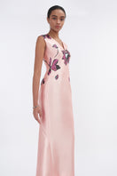 Soft pink orchid V-neck mermaid maxi dress by Tiny Ink, featuring a fitted bodice and flowing skirt, displayed on a hanger.
