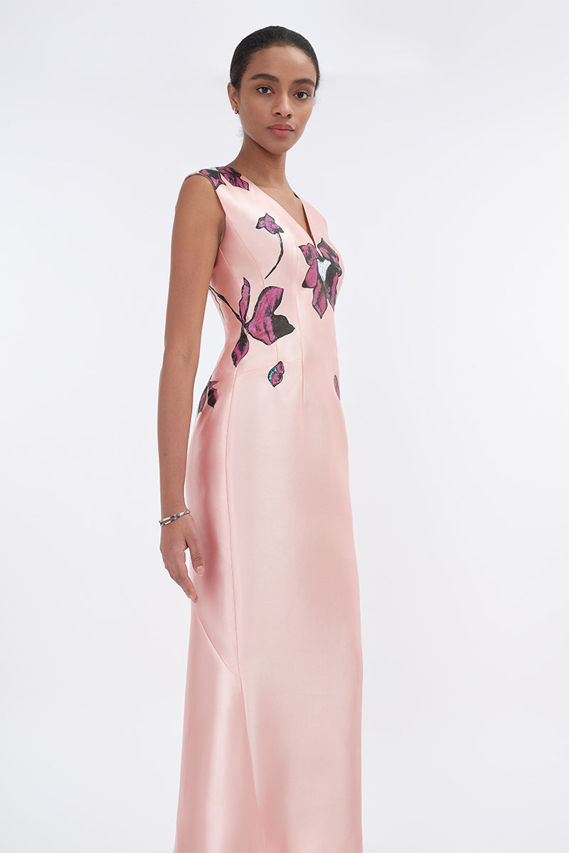 Soft pink orchid V-neck mermaid maxi dress by Tiny Ink, featuring a fitted bodice and flowing skirt, displayed on a hanger.