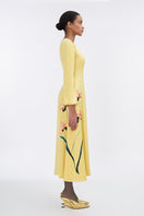 Soft yellow bishop sleeve flared midi dress by Tiny Ink, featuring flowing fabric and elegant design, displayed on a hanger.