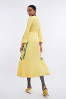 Soft yellow bishop sleeve flared midi dress by Tiny Ink, featuring a relaxed fit and elegant design, shown on a model.