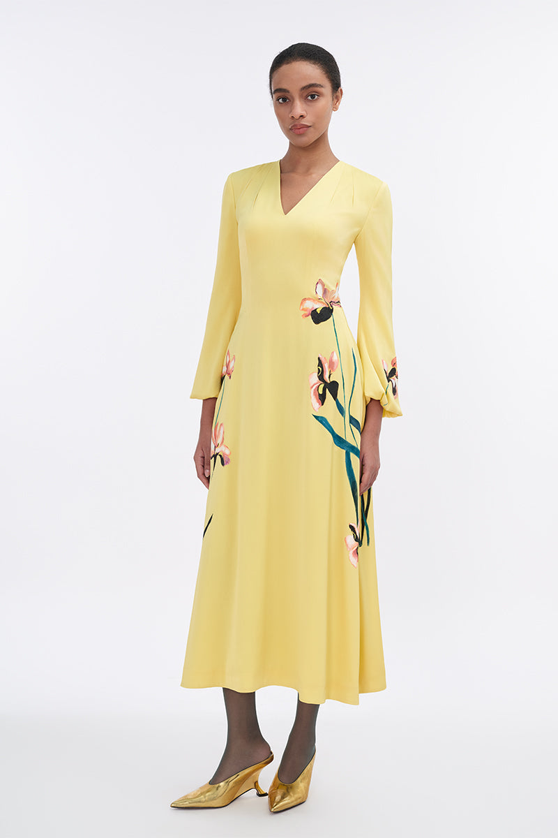 Soft yellow bishop sleeve flared midi dress by Tiny Ink, featuring flowing fabric and elegant design.