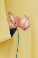 Soft yellow bishop sleeve flared midi dress by Tiny Ink, featuring flowy fabric and elegant design, shown on a model.