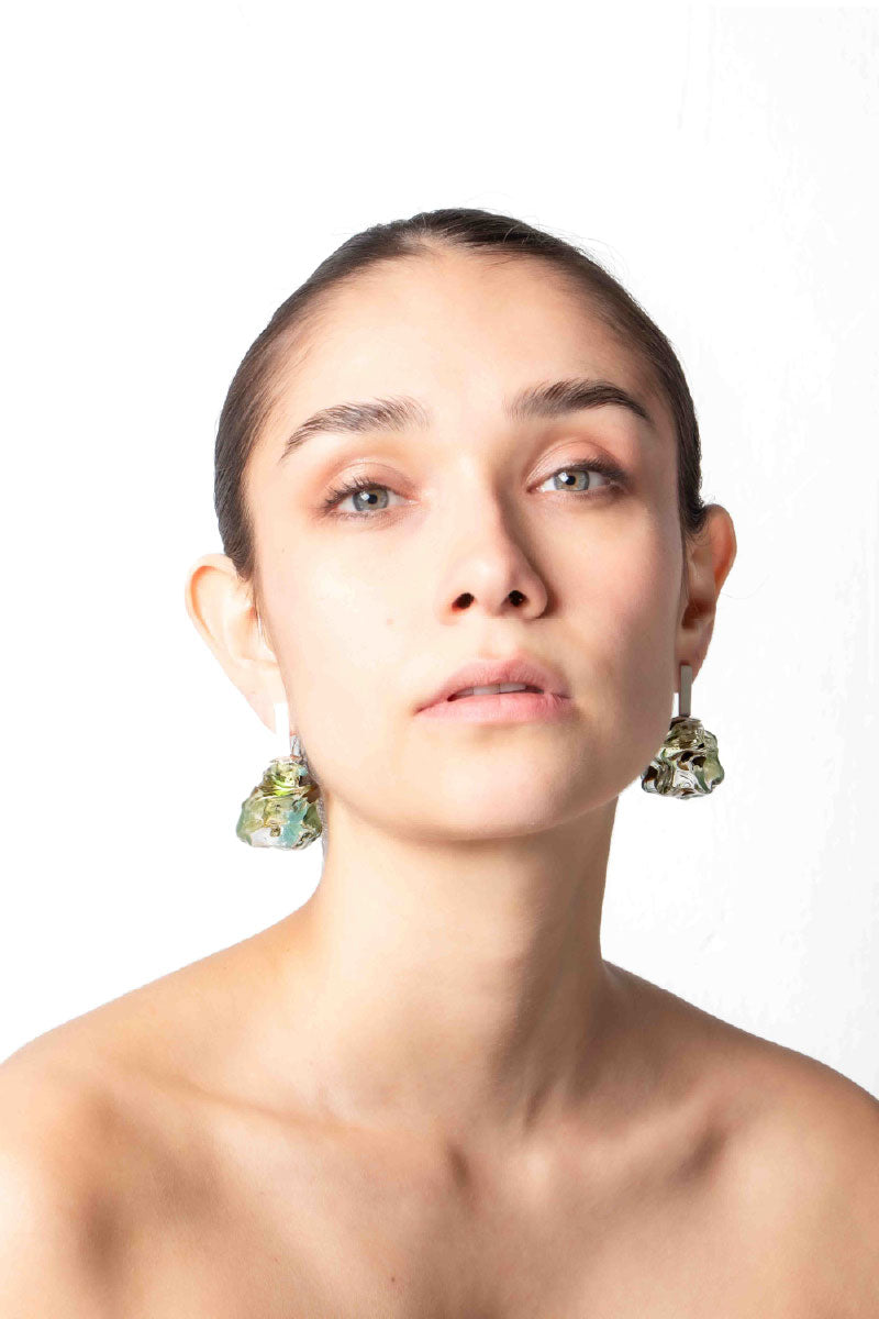 Salvára SOPLO M green earrings featuring a unique, modern design displayed on a model against a neutral background.