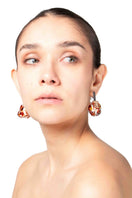 Salvárea Soplo M amber earrings featuring red and gold tones, hanging from delicate hooks, stylish and lightweight jewelry.