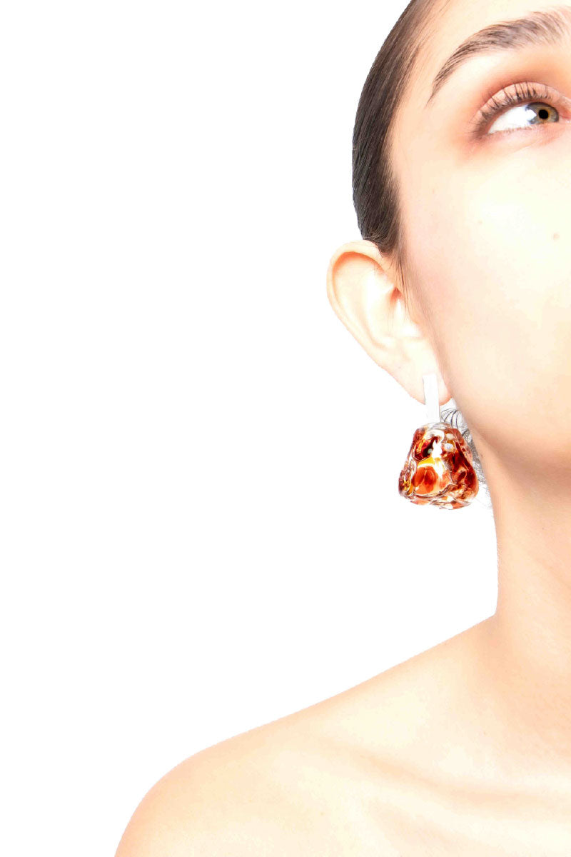 Salvárea Soplo M earrings in amber featuring a sleek, modern design with warm red tones and elegant metal accents.