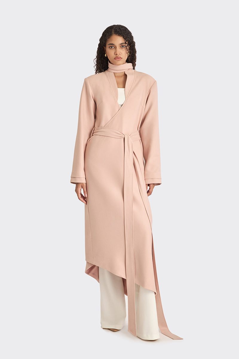Dusty pink spiral wrap coat by Stolen Stores, shown on a model with a stylish, layered design and cozy fabric.