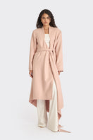 Dusty pink spiral wrap coat by Stolen Stores, shown on model, featuring a stylish twisted design and cozy fabric.