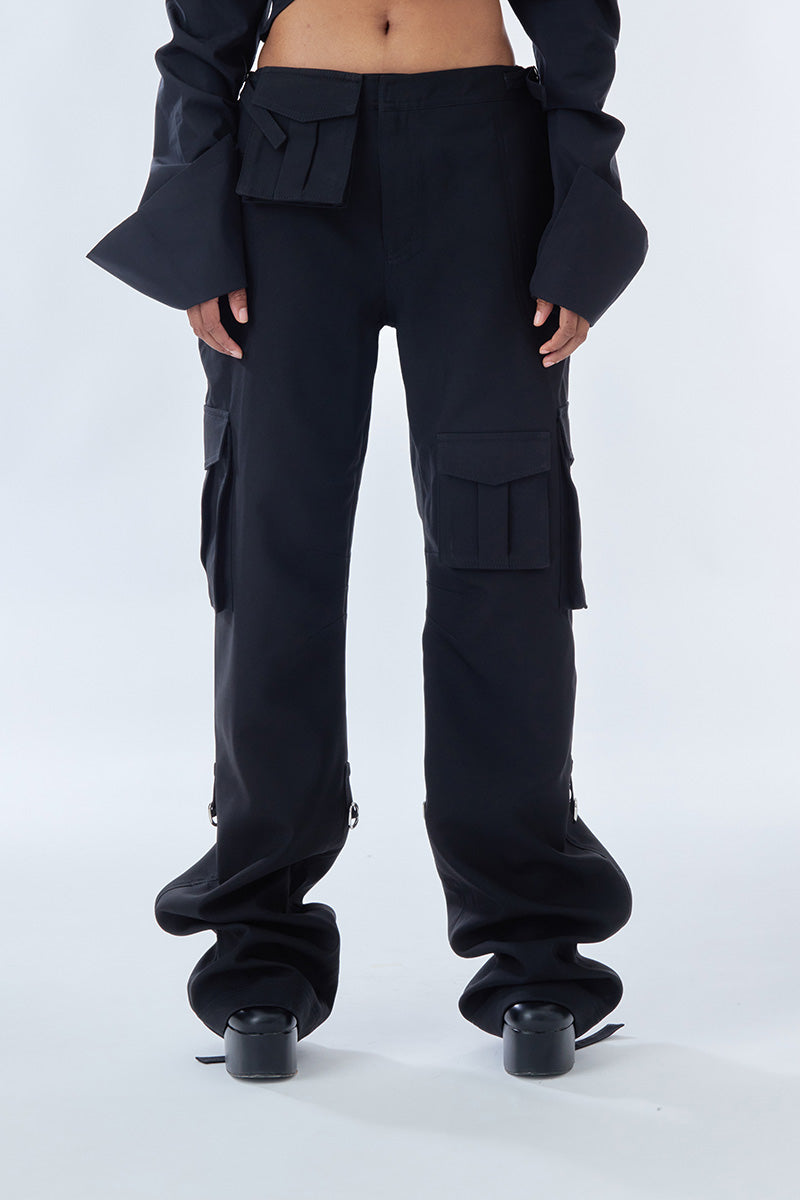 Black cargo pants by Stolen Stores featuring multiple pockets and a relaxed fit, shown on a model.
