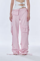 Pink cargo pants by Stolen Stores with multiple pockets, laid flat to showcase their casual, stylish design.