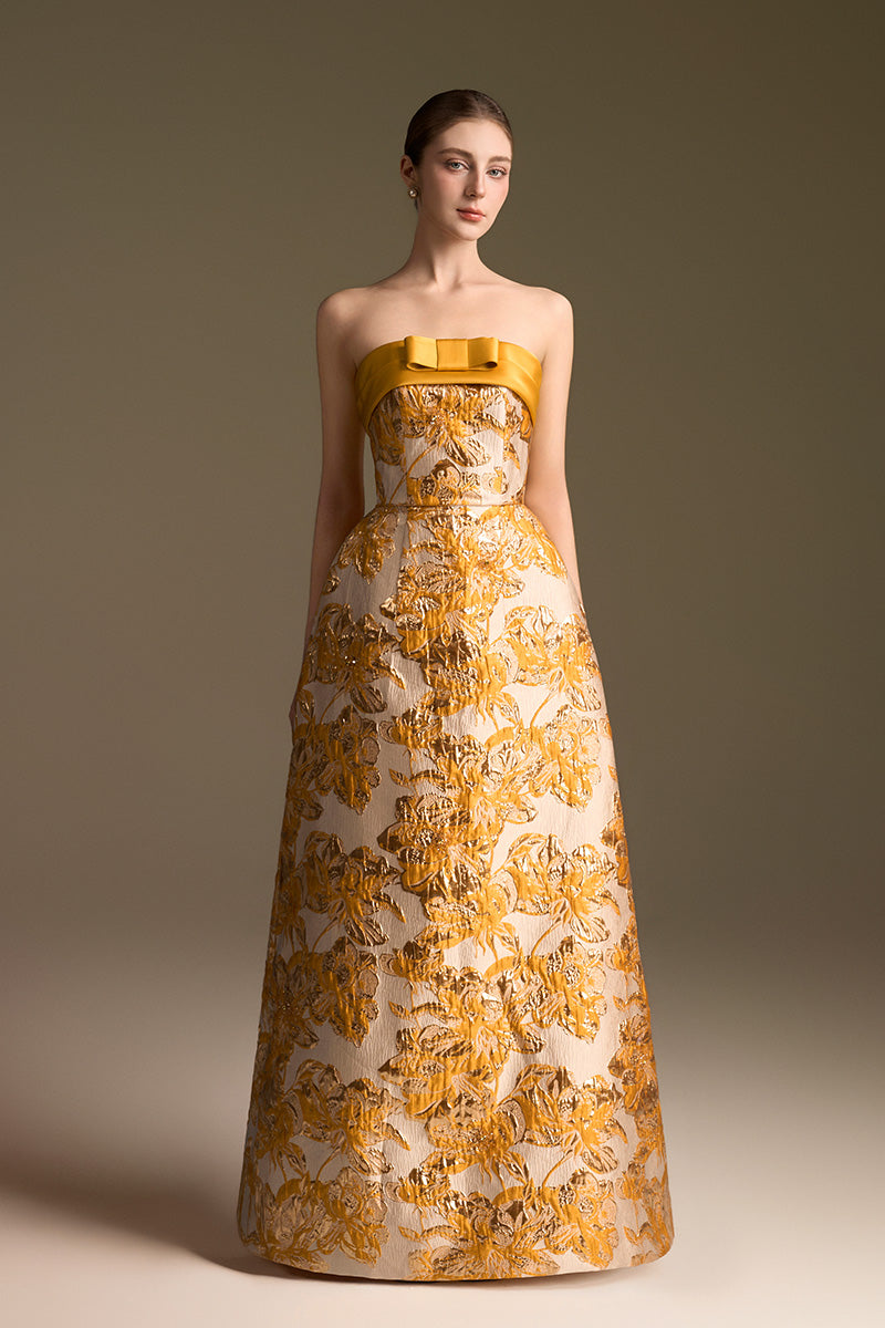 Yellow jacquard ballgown by I.H.F with strapless design and draped bow detail in agate silk fabric.