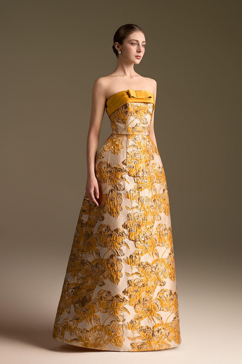 Yellow jacquard ballgown by I.H.F with strapless design and draped bow detail in agate silk fabric.