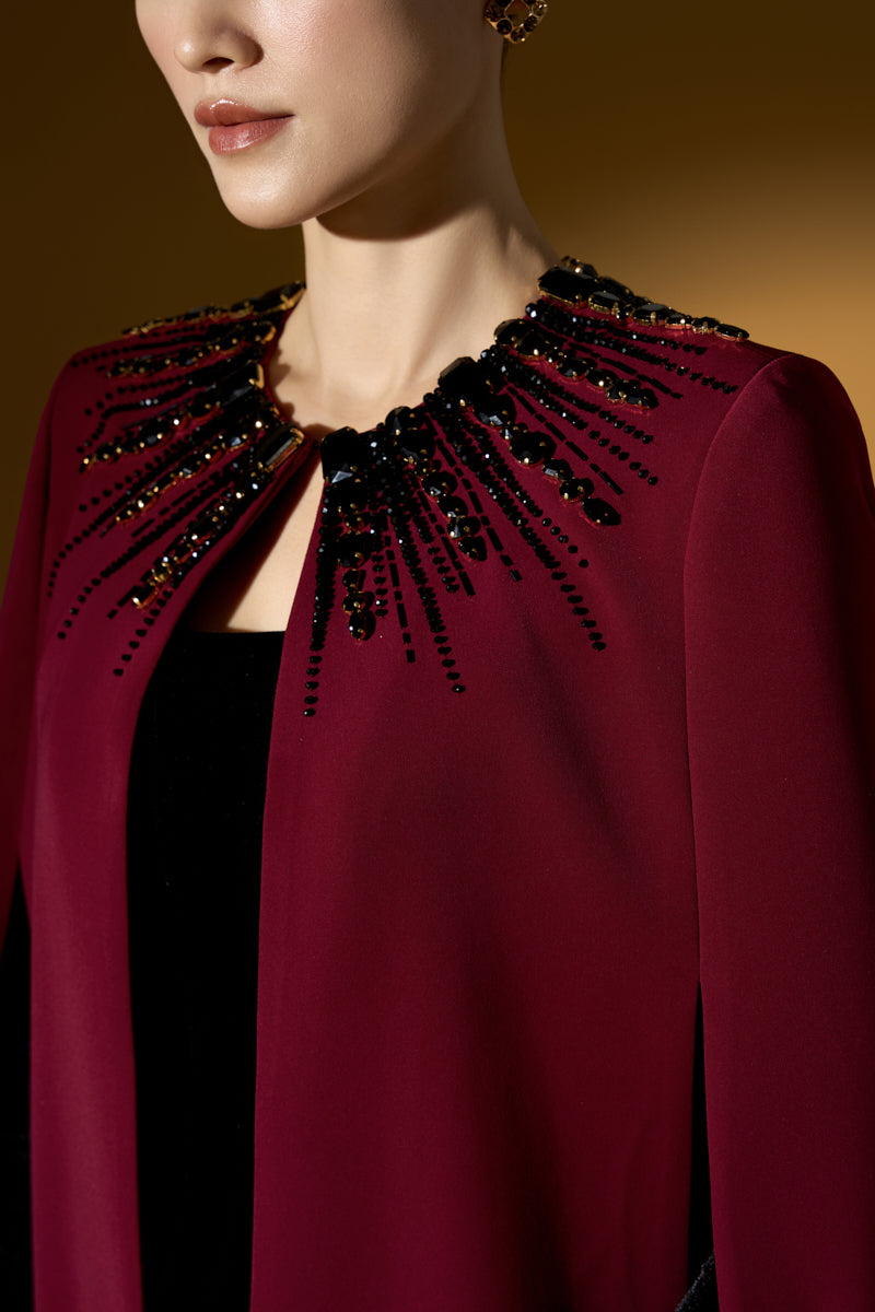 Strapless ruby crepe and lyon velvet gown by I.H.F featuring a bustier style, column silhouette, and long cape.