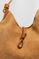 Beige suede boho shoulder bag from Folklore The Label with a relaxed, casual style and tassel details.