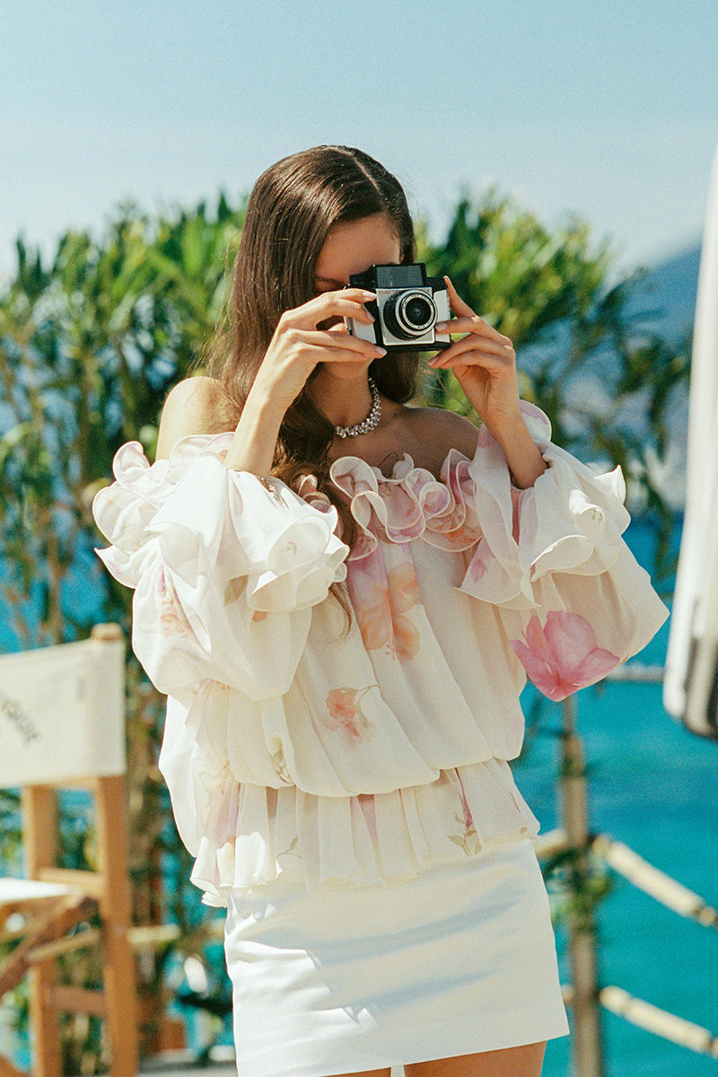 Nana Jacqueline floral summer top with ruffled sleeves in cream, featuring a vibrant floral pattern and lightweight fabric.