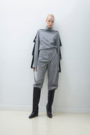 Tagg pleated wide-leg pants displayed on a hanger, showcasing their flowy fabric and relaxed fit.