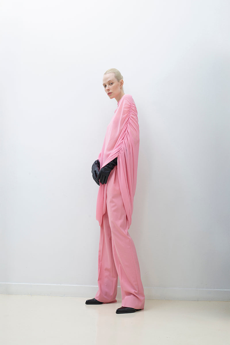 Sheer cape top by TAGG, lightweight and flowing, shown draped over a model with delicate fabric details and elegant design.