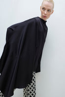 Tagg cape blouse, stylish women's top with flowing design, featuring elegant fabric and modern silhouette.