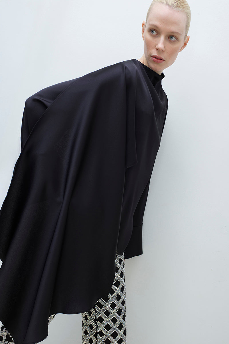 Tagg cape blouse, stylish women's top with flowing design, featuring elegant fabric and modern silhouette.