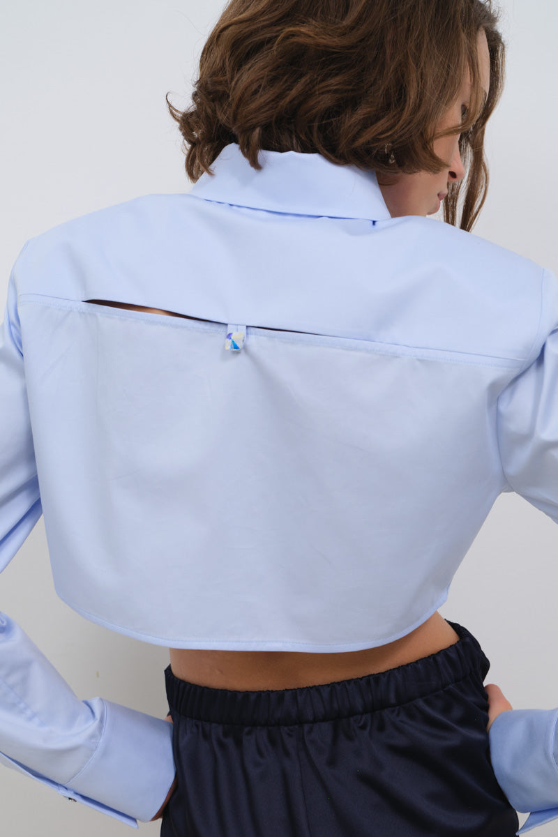 Light pink cropped poplin shirt with shoulder pads from TAGG, featuring a structured fit and classic collar design.