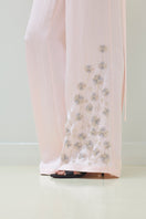 Tagg embroidered pants with elastic waistband, showcasing detailed embroidery and comfortable fit in a casual style.