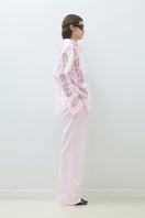 Pink embroidered oversized shirt by TAGG featuring detailed embroidery and relaxed fit, displayed on a hanger.