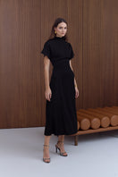 Black structured midi dress by UNDRESS, featuring a fitted silhouette and elegant design, shown on a model in this image.