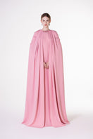 Pink velvet satin cape dress by Tracy Studio featuring a flowing gown with elegant draping and luxurious fabric.