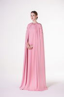 Pink velvet satin cape gown by Tracy Studio, featuring a flowing design and elegant drape for formal occasions.
