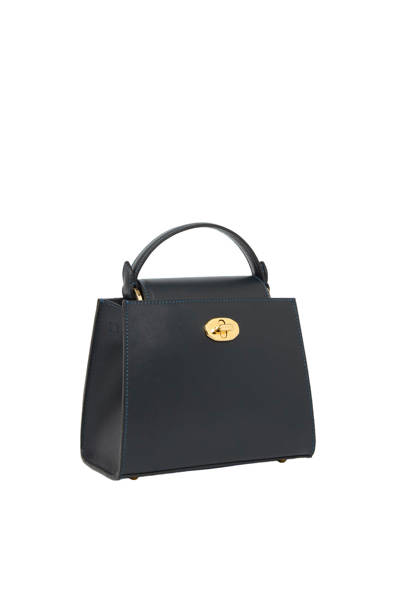 Navy TUSTING Clara top handle bag with structured design and dual top handles, shown in a close-up view.