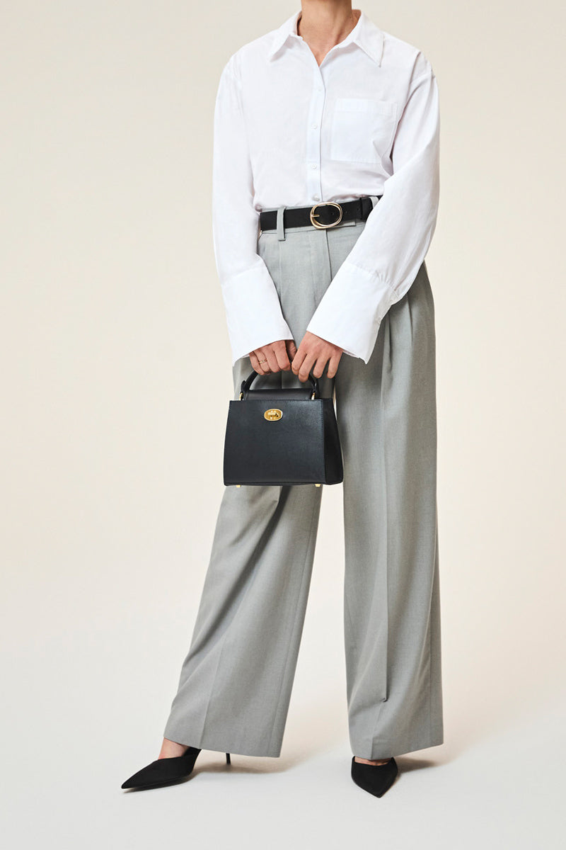 TUSTING Clara navy top handle bag with elegant design, featuring sturdy handles and a sleek, spacious interior.
