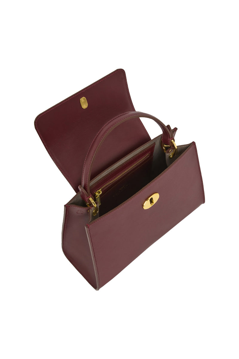 TUSTING Clara Grande top handle bag in oxblood leather with sleek design and sturdy handles, stylish for everyday use.