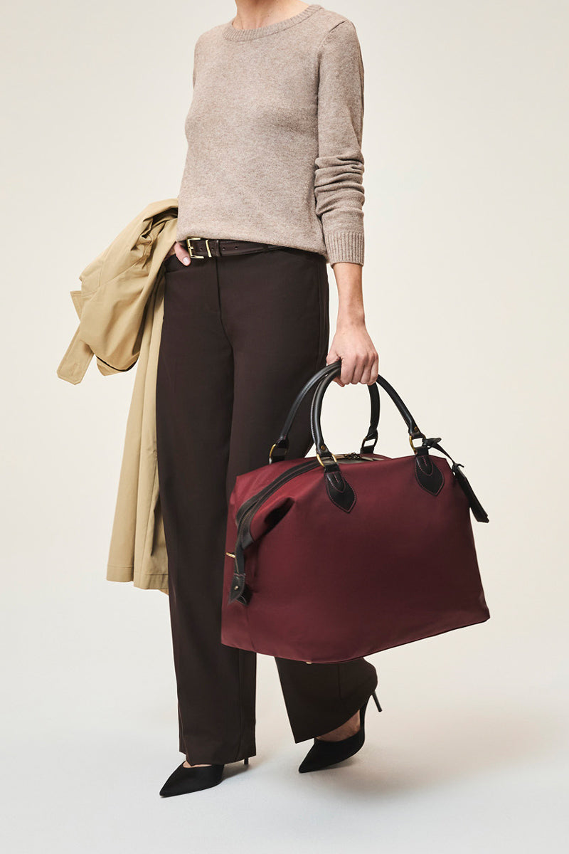 TUSTING Superlight Explorer medium top handle bag in black with sleek design and sturdy handle for versatile use.