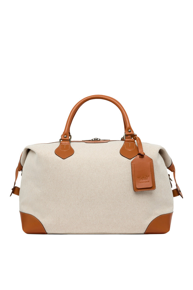 TUSTING COMO Explorer medium top handle bag in textured leather with gold-tone hardware and structured design.