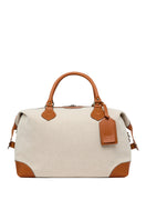 TUSTING COMO Explorer medium top handle bag in brown leather with gold hardware and adjustable strap on a plain background.